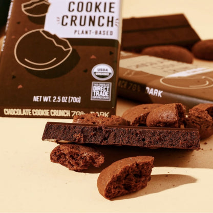 Chocolate Cookie Crunch Bars, wrapped and unwrapped surrounded by chocolate cookie crumbles.