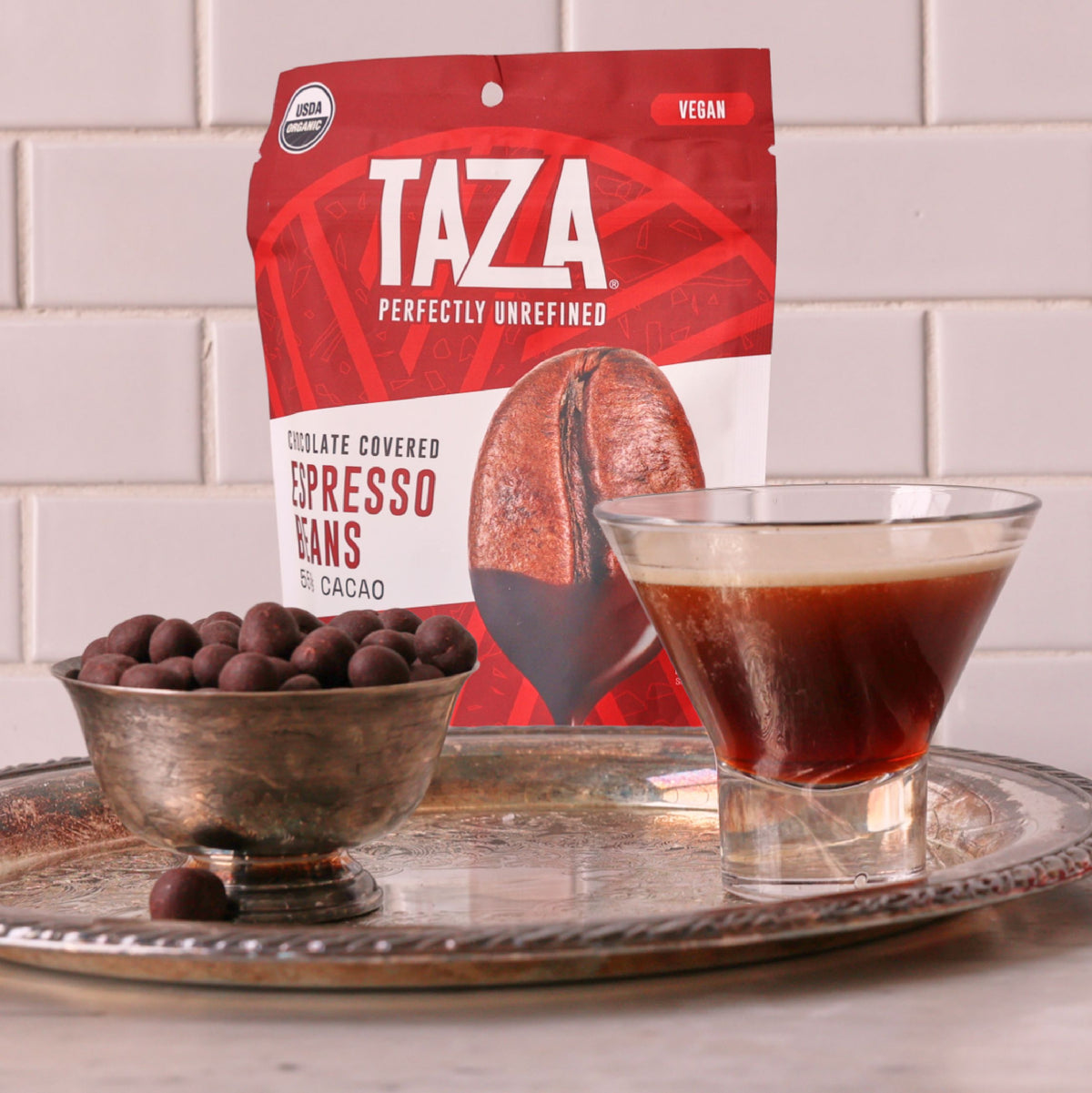 Taza dark chocolate covered espresso beans next to a small espresso cup