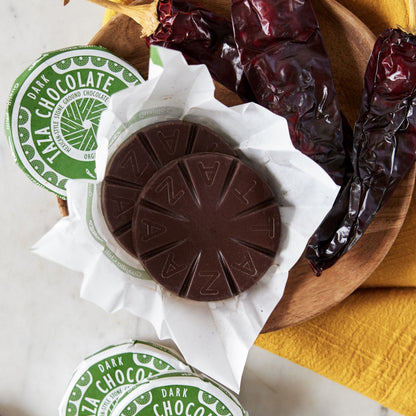 Unwrapped Guajillo Disc Surrounded by dried guajillo peppers.
