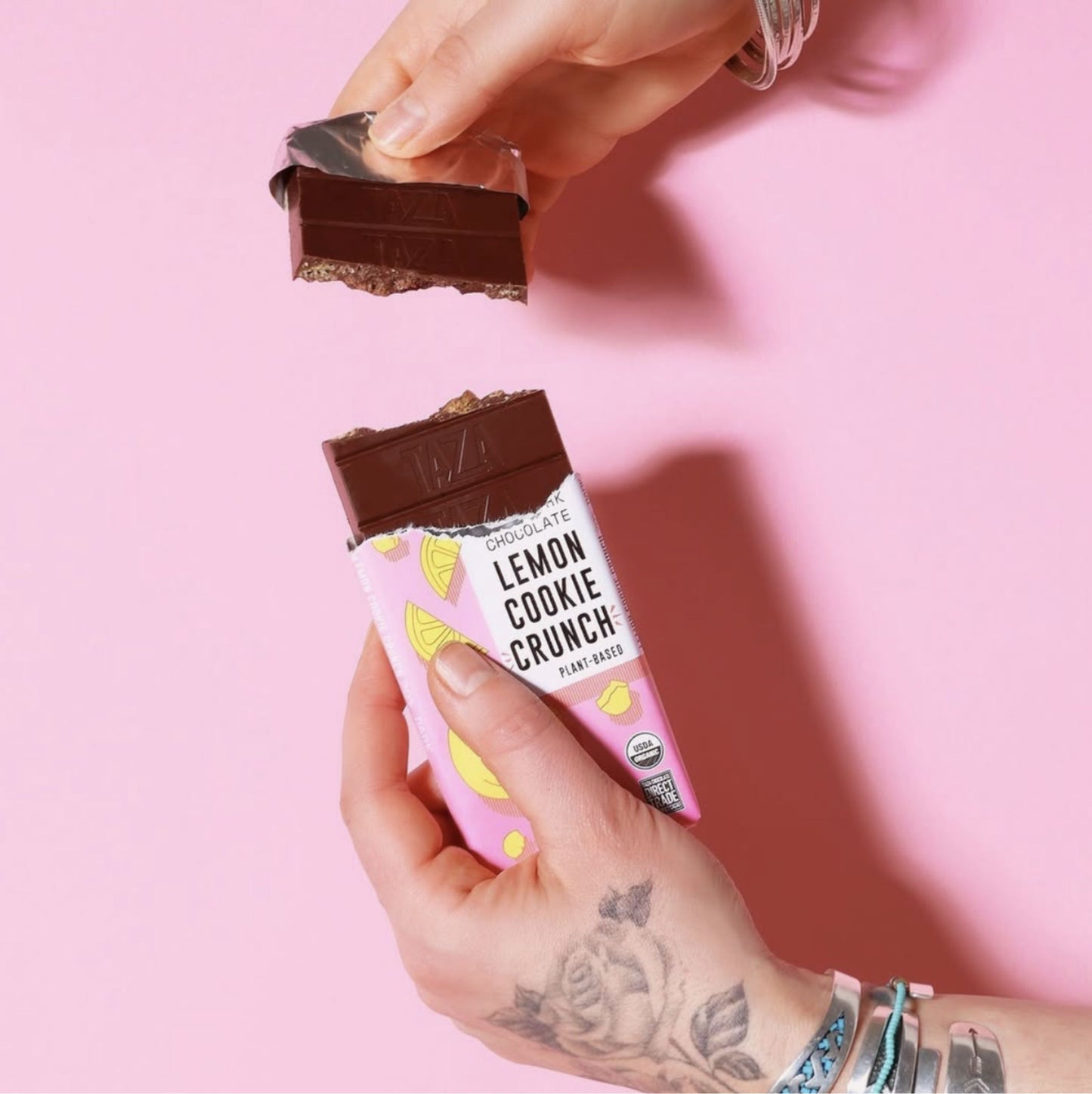 Lemon Cookie Crunch Bar partially unwrapped, being held and snapped in half.