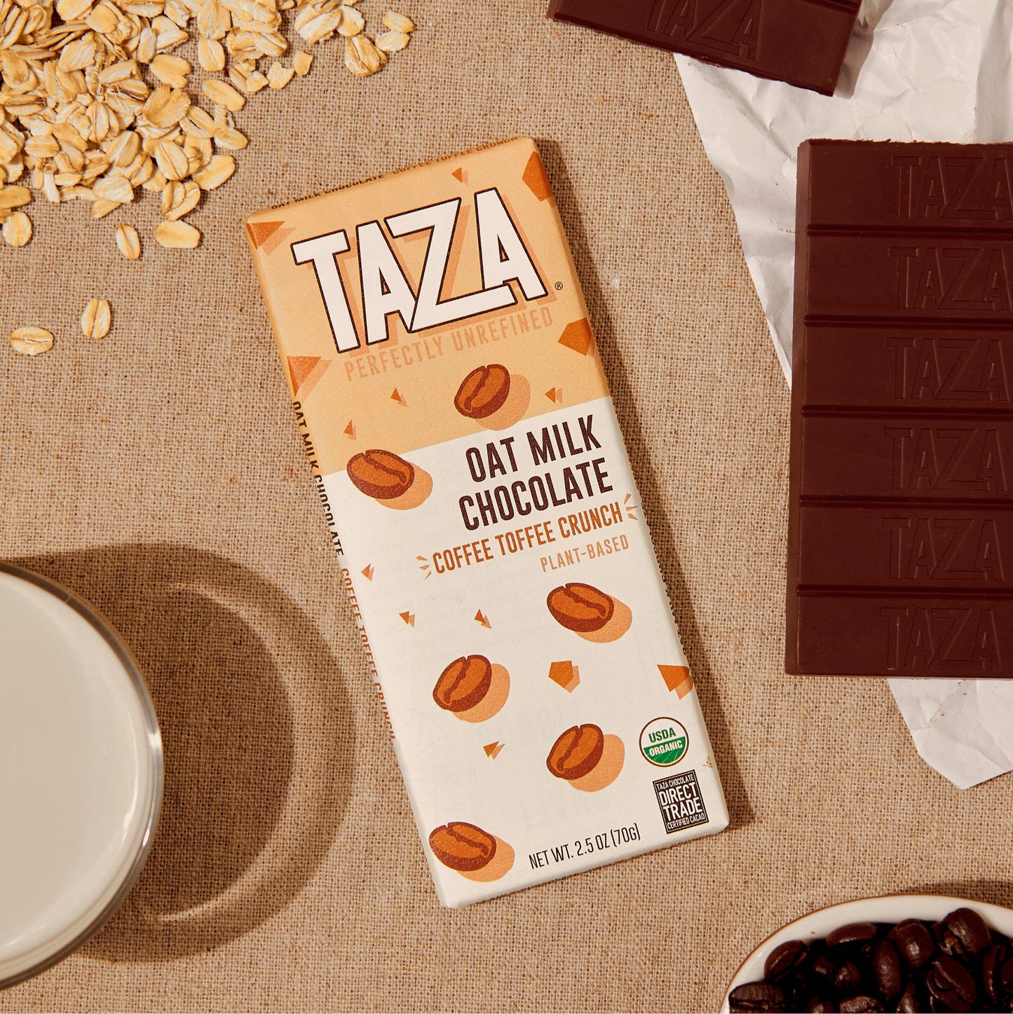 Coffee Toffee Crunch Laying next to unwrapped chocolate bar and oats.