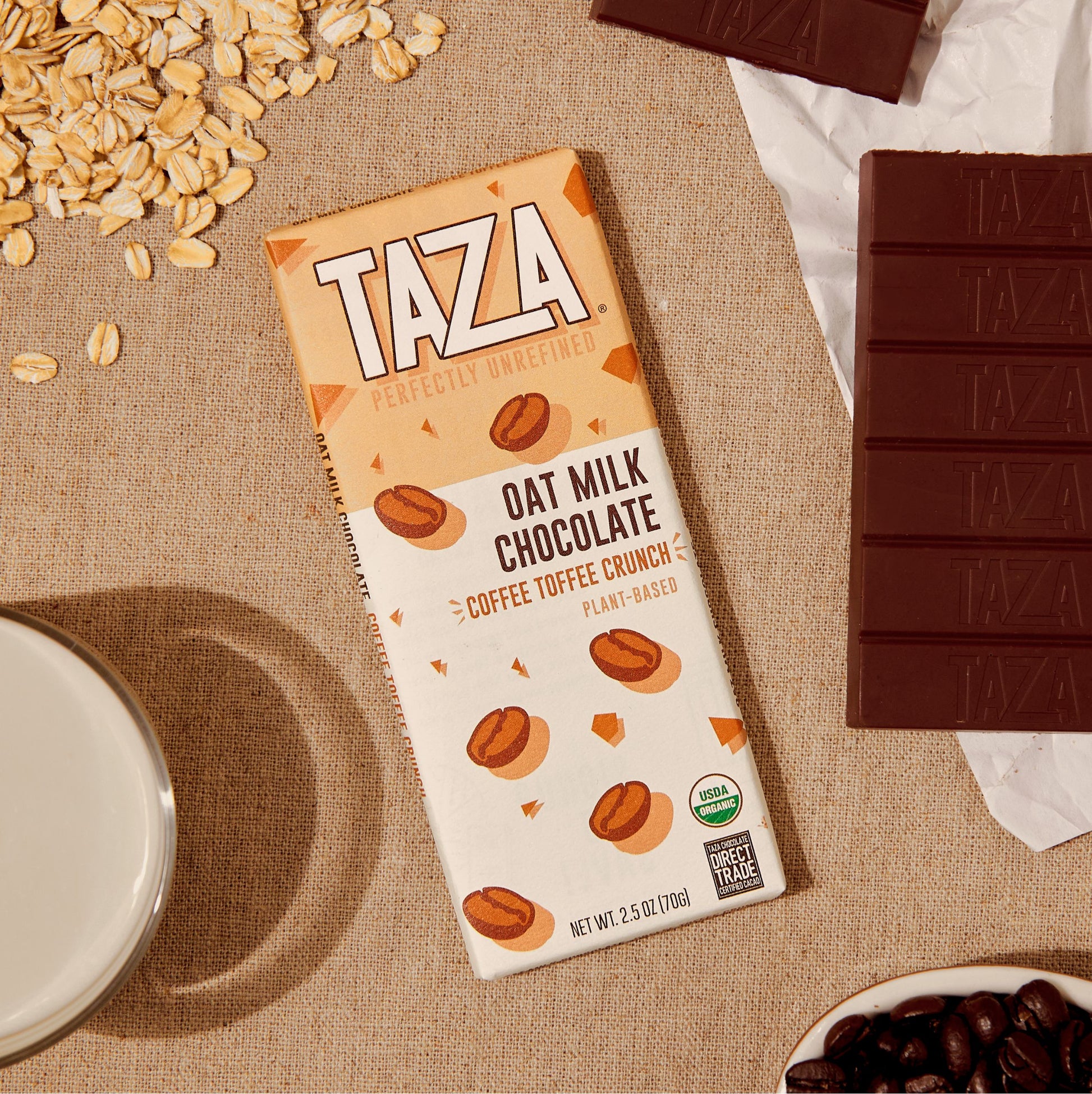 Coffee Toffee Crunch Laying next to unwrapped chocolate bar and oats.