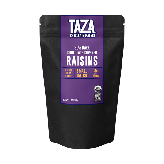 A black stand-up pouch of TAZA Chocolate Makers 80% Dark Chocolate Covered Raisins, featuring a prominent purple label with white and yellow text.
