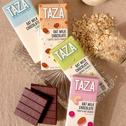 Taza Oat Milk Bars spread out with Oats and Chocolate.