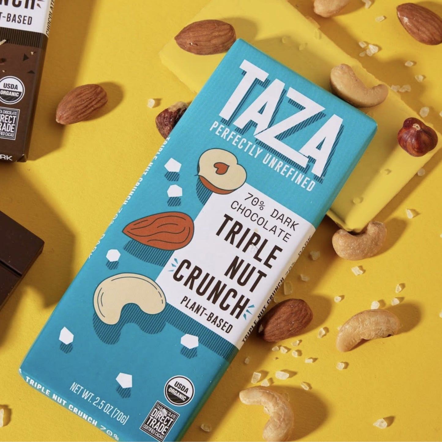 Triple Nut Crunch Bar laying next to scattered nuts and salt.